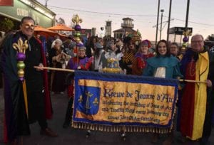 Jesters carrying birthday cake and parade front banner